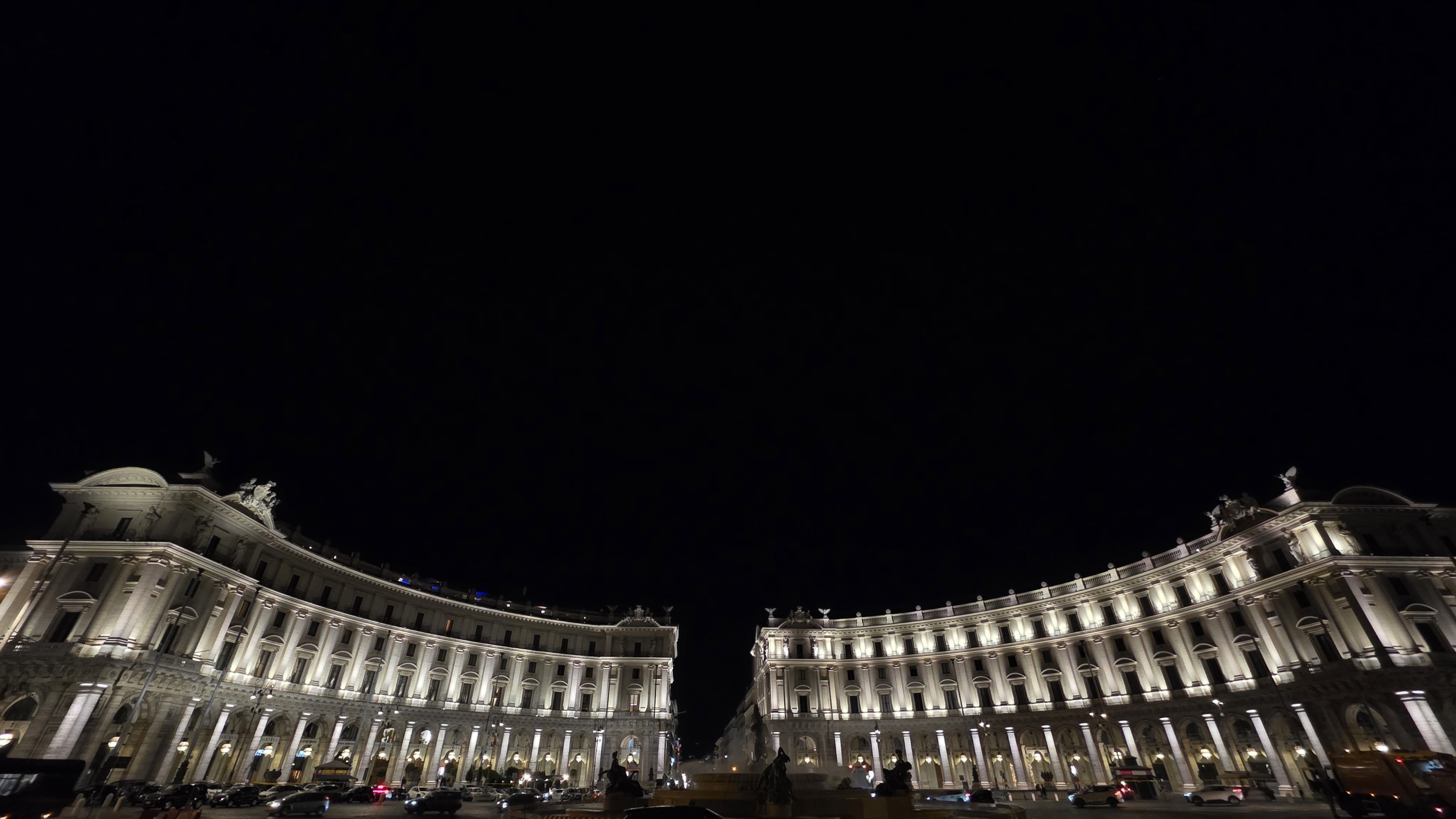 A long illuminated colonnade glowing against a black sky