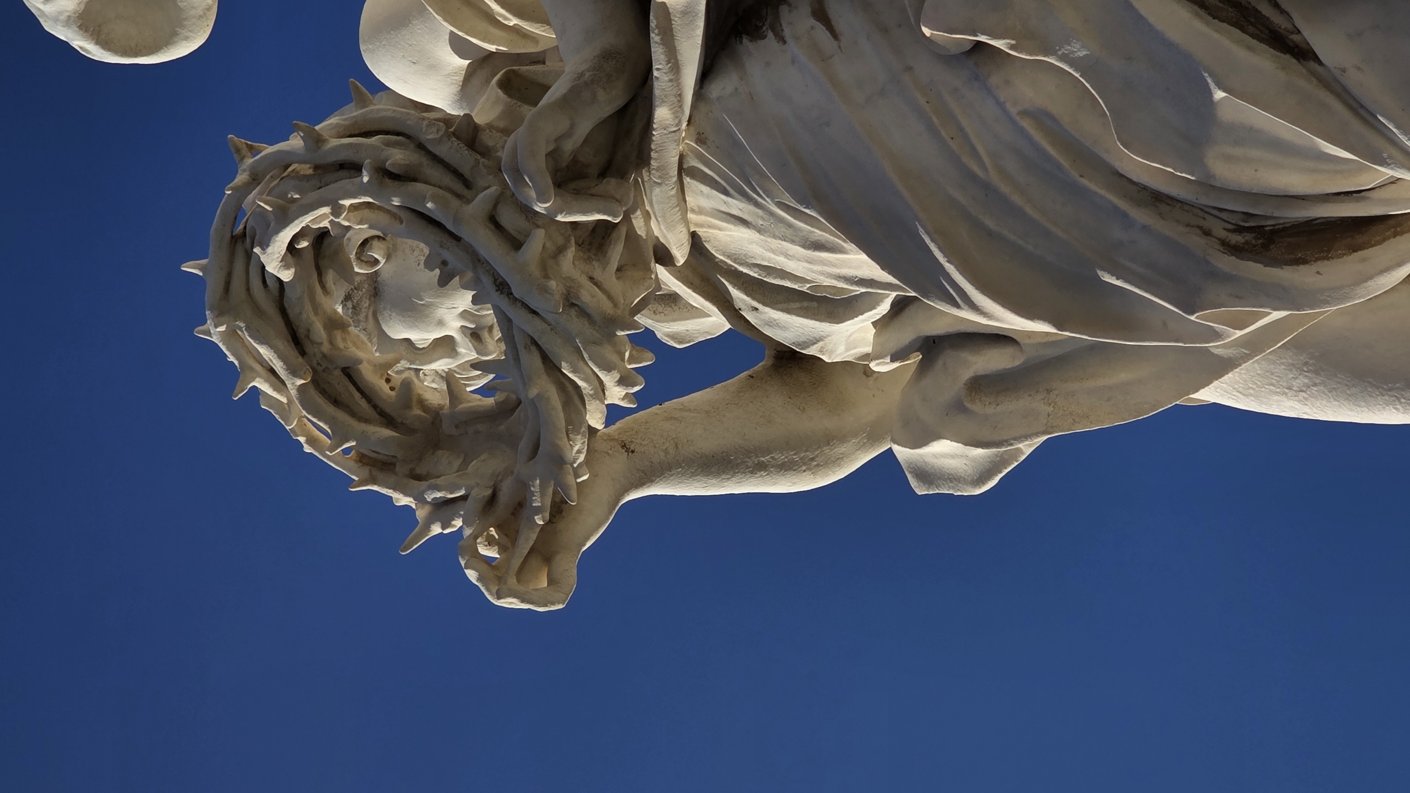 A bridge angel carrying the crown of thorns against deep blue
