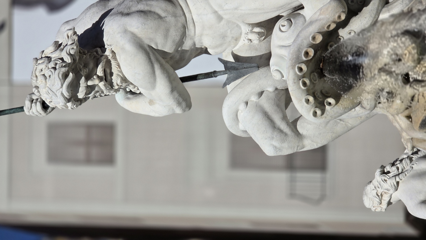 A marble triton wrestling in a baroque fountain