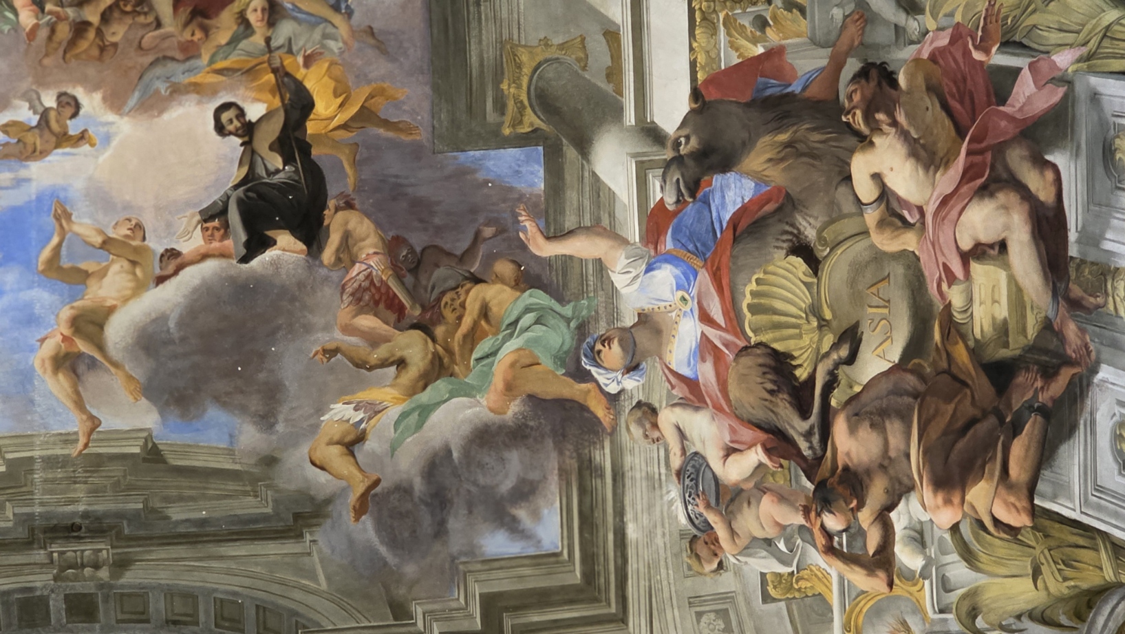 A painted saint borne upward among angels on a church ceiling