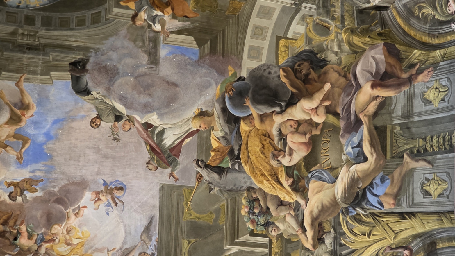 Swirling clouds and figures at the crown of a painted vault