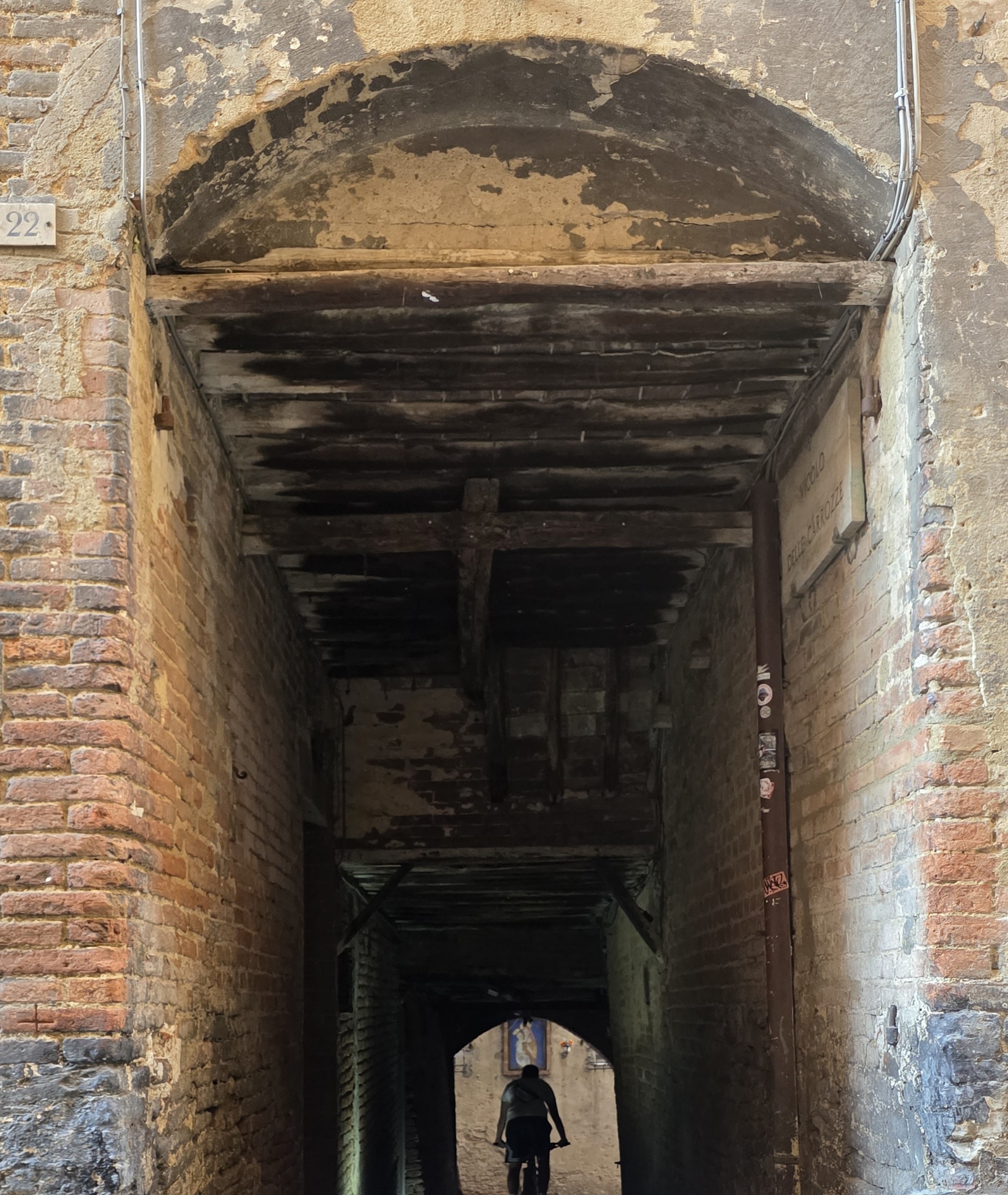 A figure silhouetted at the far end of a dark vaulted passage