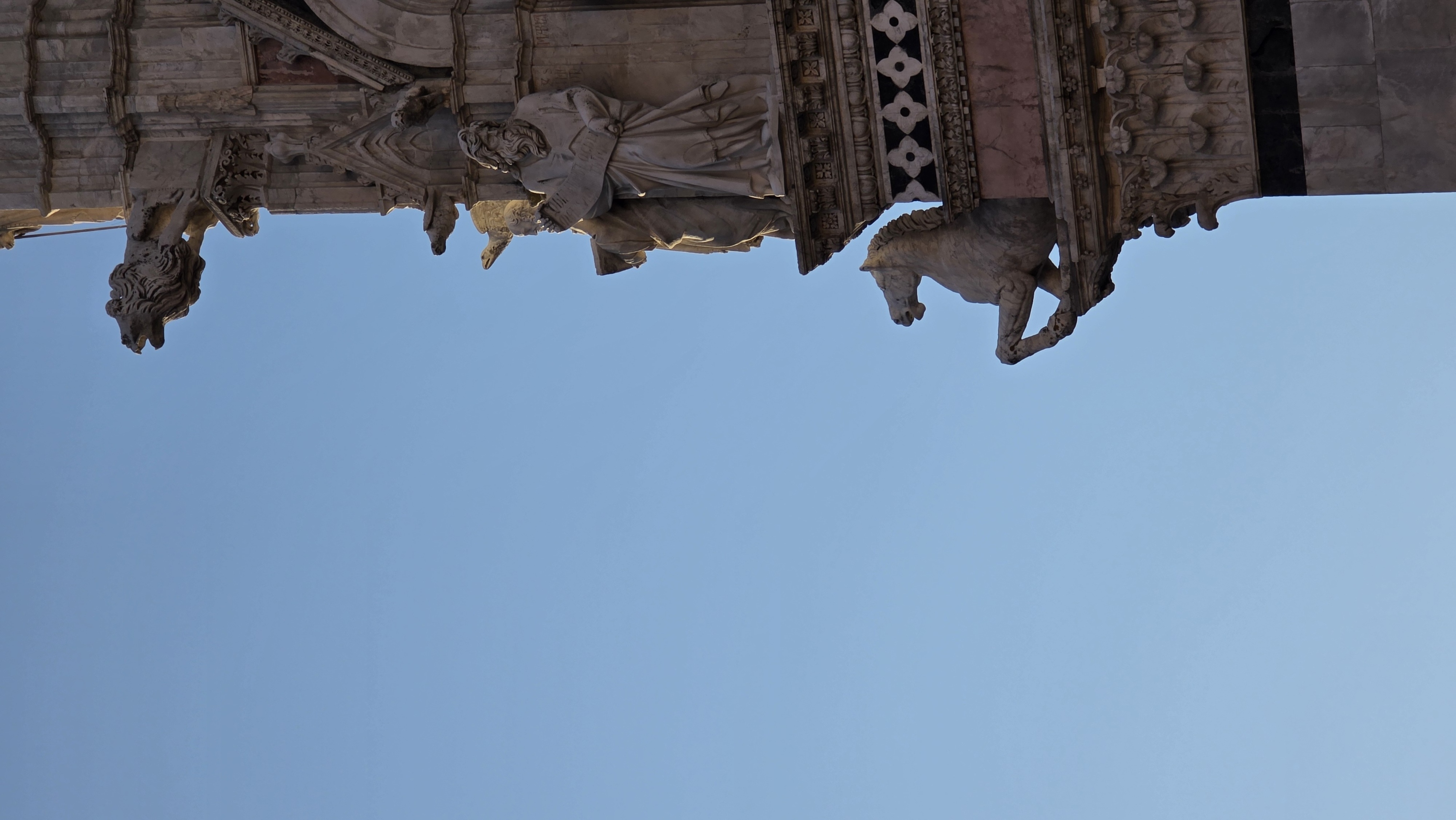 A carved pinnacle of the cathedral cut against plain blue sky