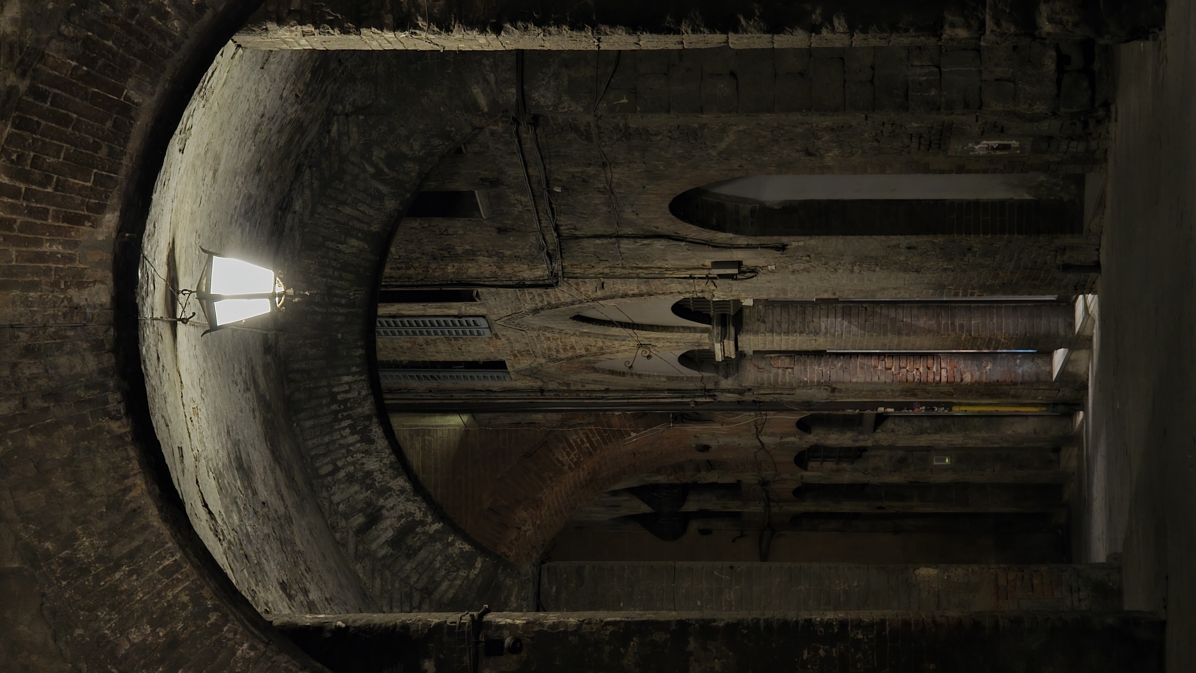 A lantern in a dark vaulted arcade
