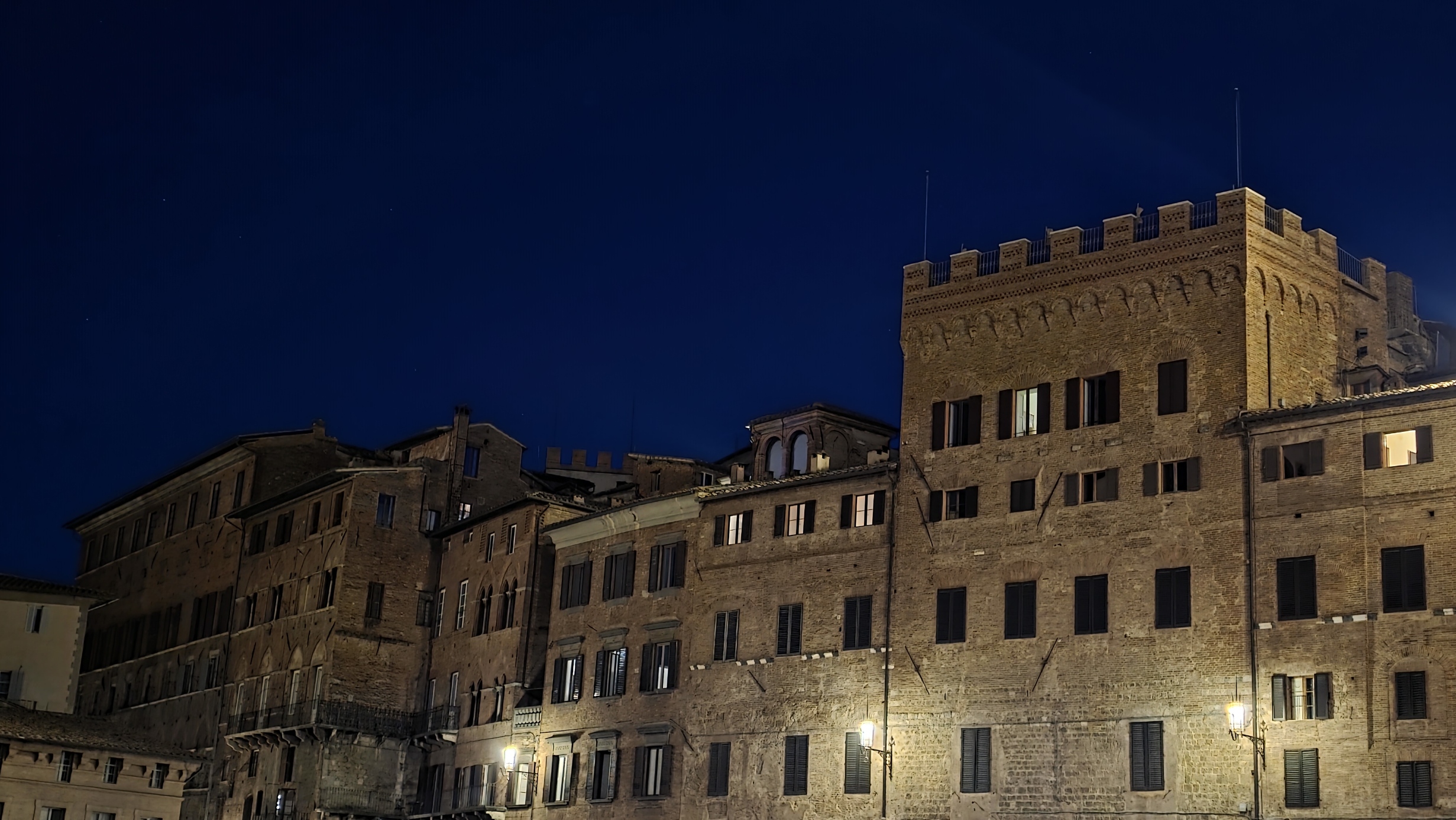 Lit windows of the Palazzo Pubblico across the Piazza del Campo at night